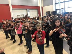 Dynamics students learning violin together – Source: CBOI